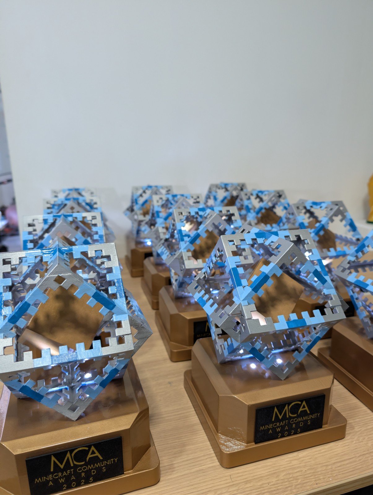 Trofeos Minecraft Community Awards 2025 para Spreen con cubo pixelado, base dorada y electrónica integrada
